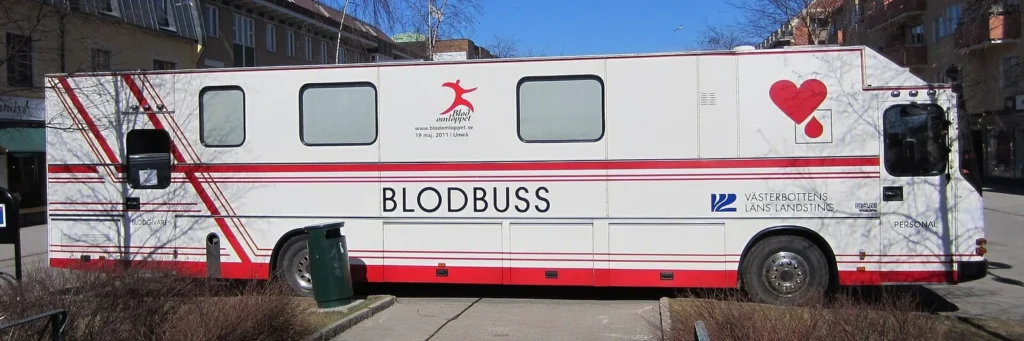 A mobile blood donation bus parked in a city street